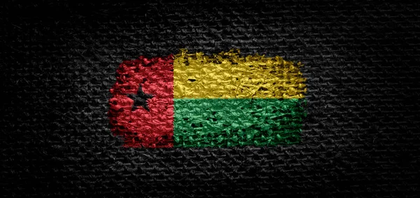 Bissau-Guinea nemzeti lobogója a sötét anyagról — Stock Fotó