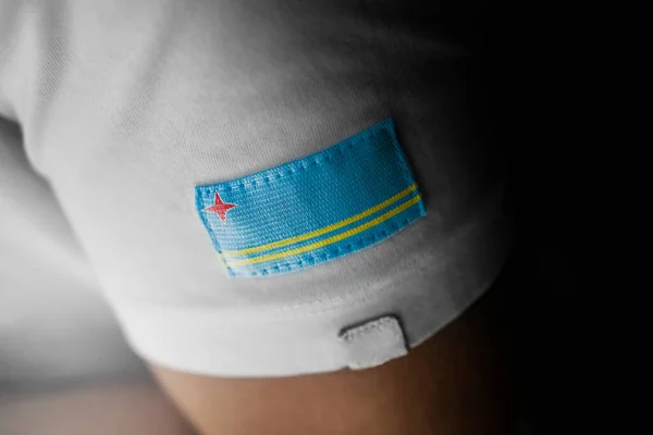 Patch da bandeira nacional do Aruba em uma camiseta branca — Fotografia de Stock