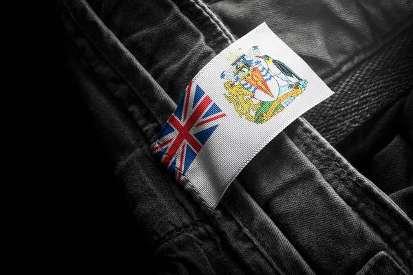 Étiquette sur vêtements sombres sous la forme du drapeau du territoire antarctique britannique — Photo