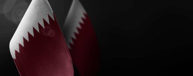 Koyu arkaplanda Katar 'ın küçük ulusal bayrakları