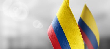 Small national flags of the Colombia on a light blurry background clipart