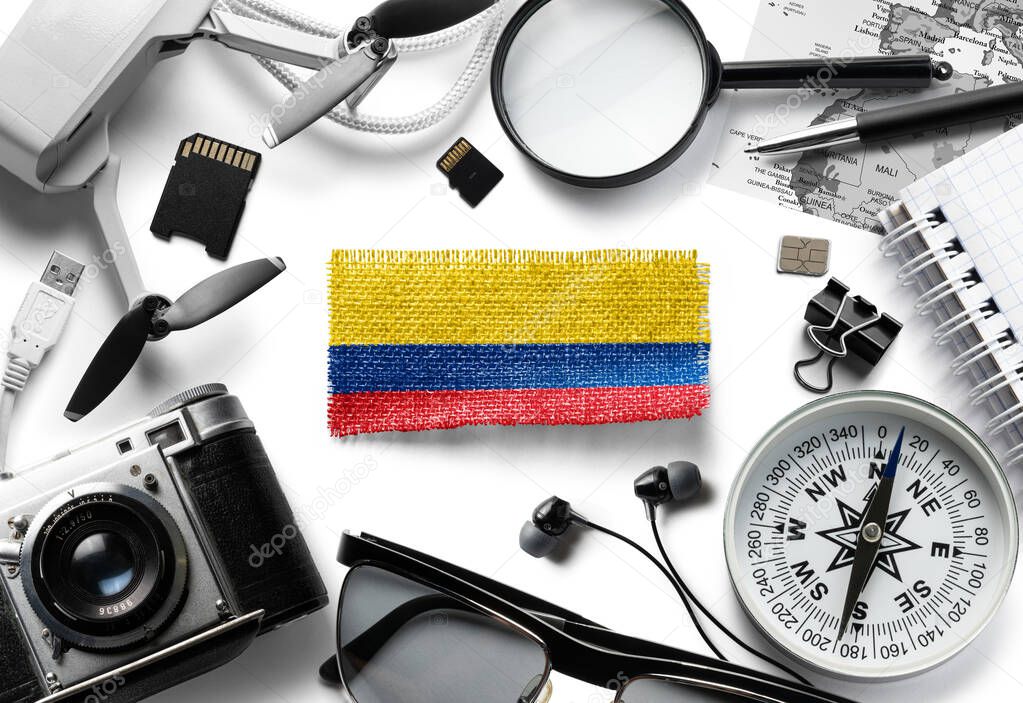 Flag of Colombia and travel accessories on a white background.