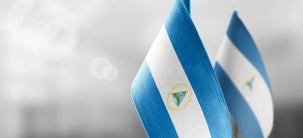 Small national flags of the Nicaragua on a light blurry background — Stock Photo, Image