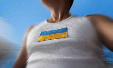Sporcunun göğsünde Ukrayna bayrağı.