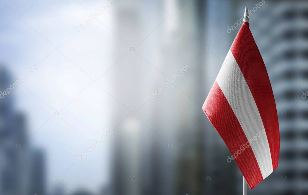 A small flag of Austria on the background of a blurred background