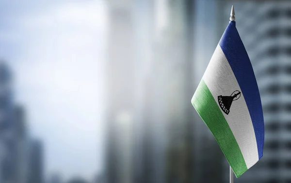 A small flag of Lesotho on the background of a blurred background — Stock Photo, Image