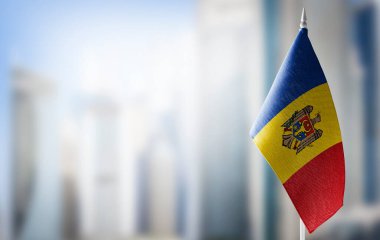 A small flag of Moldavia on the background of a blurred background clipart