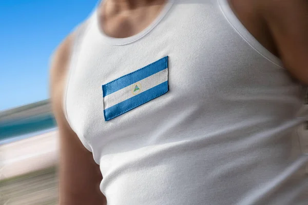 Nationell flagga Nicaragua på idrottare bröstet — Stockfoto