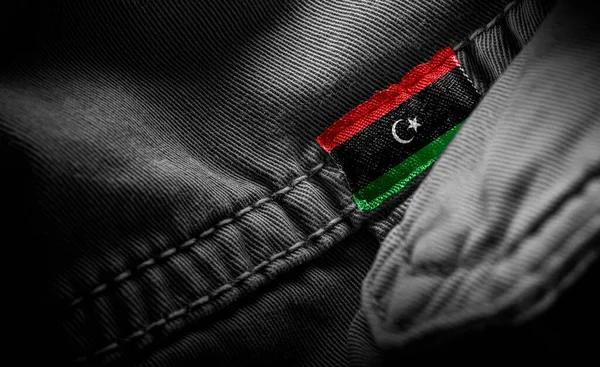 Tagg på mörka kläder i form av Libyens flagga — Stockfoto