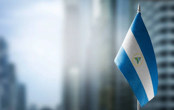 Una pequeña bandera de Nicaragua en el fondo de un fondo borroso — Foto de Stock