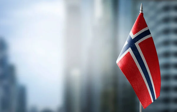Uma pequena bandeira da Noruega no fundo de um fundo embaçado — Fotografia de Stock
