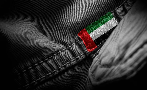Znacznik na ciemnej odzieży w formie flagi Zjednoczonych Emiratów Arabskich — Zdjęcie stockowe