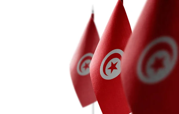 Pequenas bandeiras nacionais da Tunísia sobre um fundo branco — Fotografia de Stock