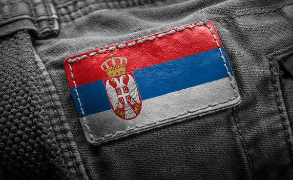 Tagg på mörka kläder i form av flagga Serbien — Stockfoto
