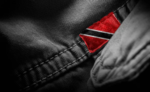 Štítek na tmavém oblečení v podobě vlajky Trinidad a Tobago — Stock fotografie