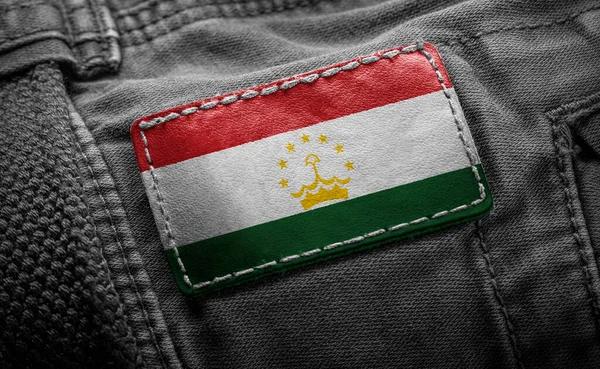 Tagg på mörka kläder i form av Tadzjikistans flagga — Stockfoto