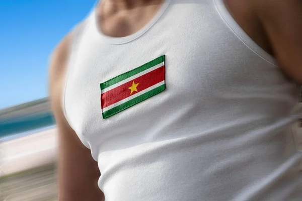 The national flag of Suriname on the athletes chest — Stock Photo, Image