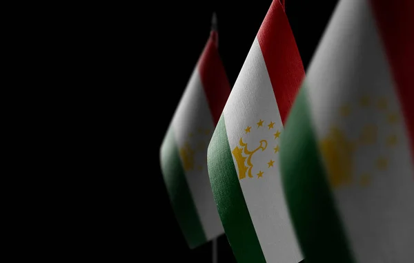 Pequeñas banderas nacionales de Tayikistán sobre un fondo negro —  Fotos de Stock