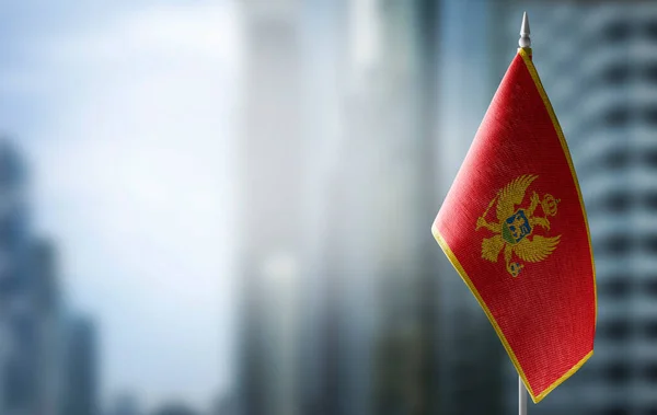 Un mic steag al Muntenegrului pe fundalul unui fundal neclar — Fotografie, imagine de stoc