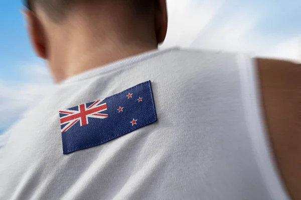 La bandera nacional de Nueva Zelanda en los atletas espalda — Foto de Stock