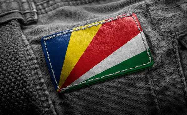 Etiqueta en la ropa oscura en forma de la bandera de las Seychelles —  Fotos de Stock