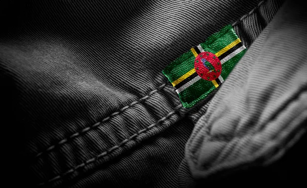 Метка на темной одежде в виде флага Доминики — стоковое фото