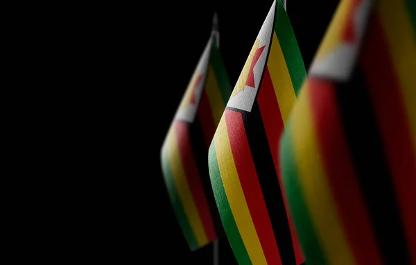 Kleine Nationalflaggen Simbabwes auf schwarzem Hintergrund — Stockfoto