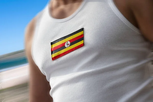 La bandera nacional de Uganda en el pecho de los atletas —  Fotos de Stock