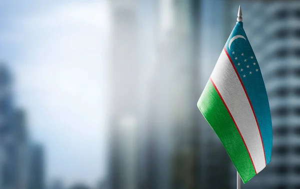 Невеликий прапор Узбекистану на тлі розмитого фону. — стокове фото