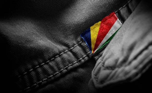 Etiqueta en la ropa oscura en forma de la bandera de las Seychelles —  Fotos de Stock