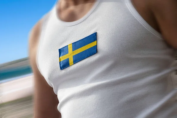 Nationell flagga av Sverige på idrottare bröstet — Stockfoto