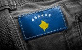 Značka na tmavém oblečení v podobě vlajky Kosova