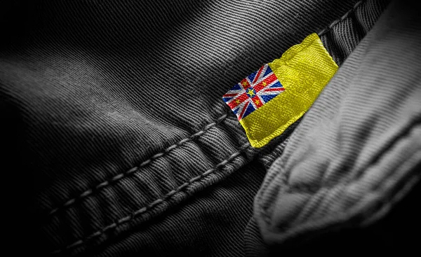 Étiquette sur vêtements sombres sous la forme du drapeau de la Niue — Photo