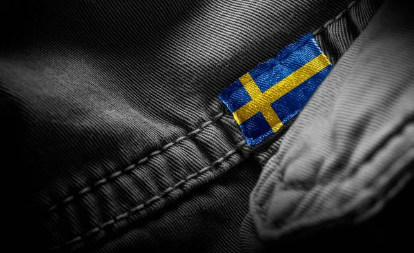 Tag em roupas escuras sob a forma da bandeira da Suécia — Fotografia de Stock