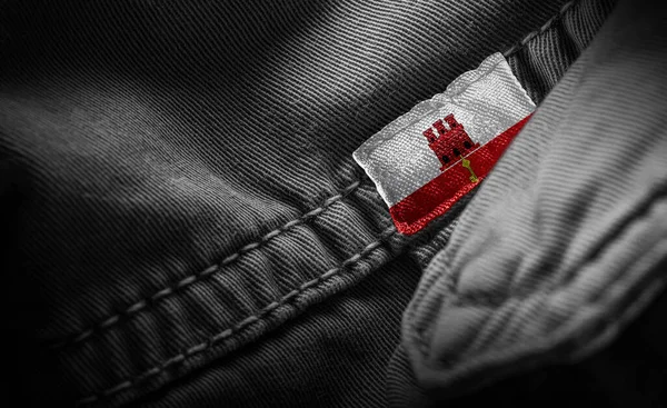 Tag on dark clothing in the form of the flag of the Gibraltar — Stock Photo, Image