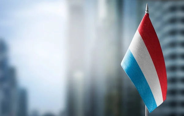 Una pequeña bandera de Luxemburgo en el fondo de un fondo borroso —  Fotos de Stock