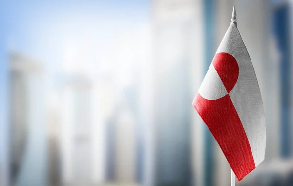 A small flag of Greenland on the background of a blurred background — Stock Photo, Image