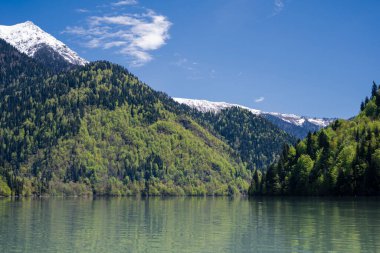 Ritsa Gölü ve Abhazya Cumhuriyeti 'ndeki dağlar. Açık güneşli gün 12 Mayıs 2021