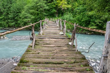 Abhazya Cumhuriyeti 'ndeki Batı Gumista Nehri üzerinde eski ahşap bir köprü. Bulutlu Gün 17 Mayıs 2021