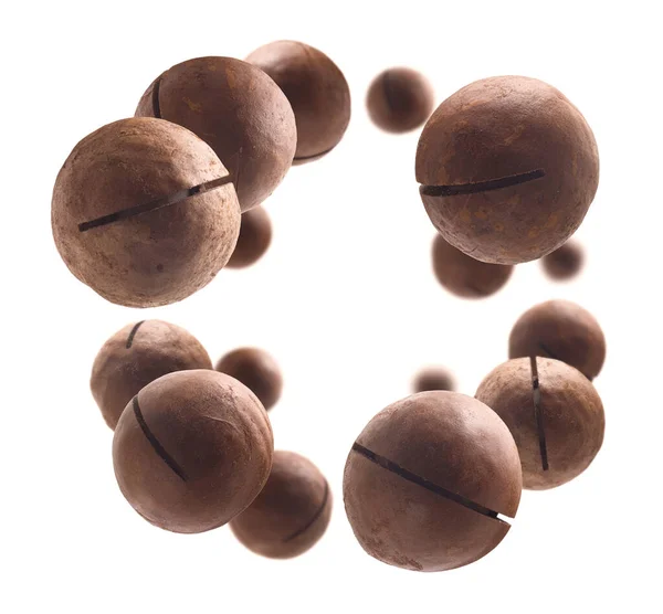 Ungeschälte Macadamia-Nüsse schweben auf weißem Hintergrund — Stockfoto