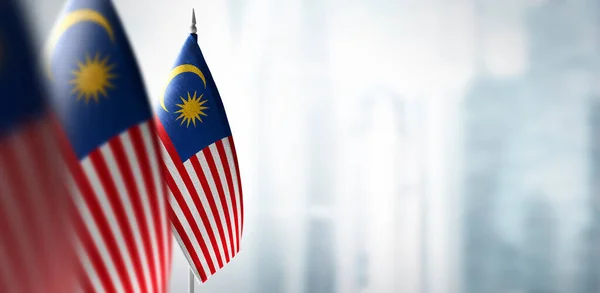 Małe flagi Malezji na rozmytym tle miasta — Zdjęcie stockowe