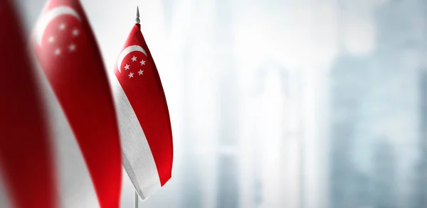 Small flags of Singapore on a blurry background of the city — Stock Photo, Image