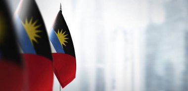 Şehrin bulanık arka planında Antigua ve Barbuda 'nın küçük bayrakları