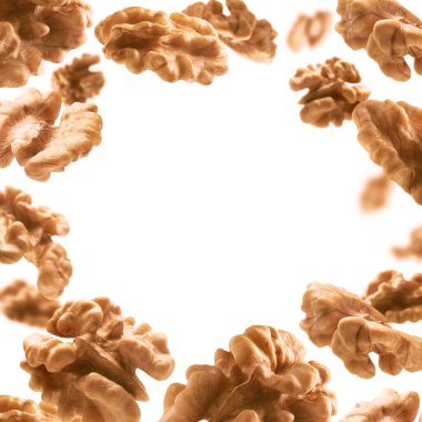 Kabuktan soyulmuş, ceviz çekirdekleri beyaz bir zeminde uçar.