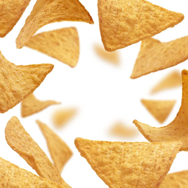Chips di mais di forma triangolare levitare su uno sfondo bianco — Foto Stock