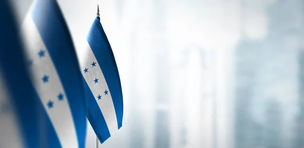 Malé vlajky Hondurasu na rozmazaném pozadí města — Stock fotografie