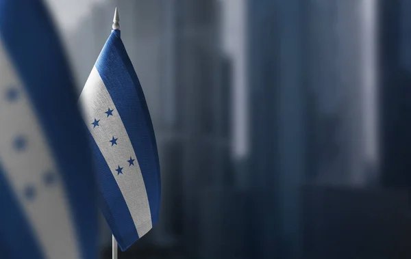 Kleine vlaggen van Honduras op een wazige achtergrond van de stad — Stockfoto