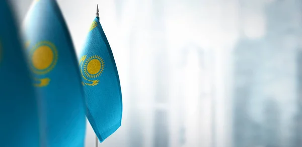 Małe flagi Kazachstanu na rozmytym tle miasta — Zdjęcie stockowe