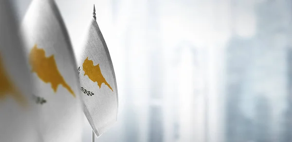 Małe flagi Cypru na rozmytym tle miasta — Zdjęcie stockowe