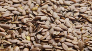Keten tohumları yavaş çekimde dönen uçtan dökülüyor.